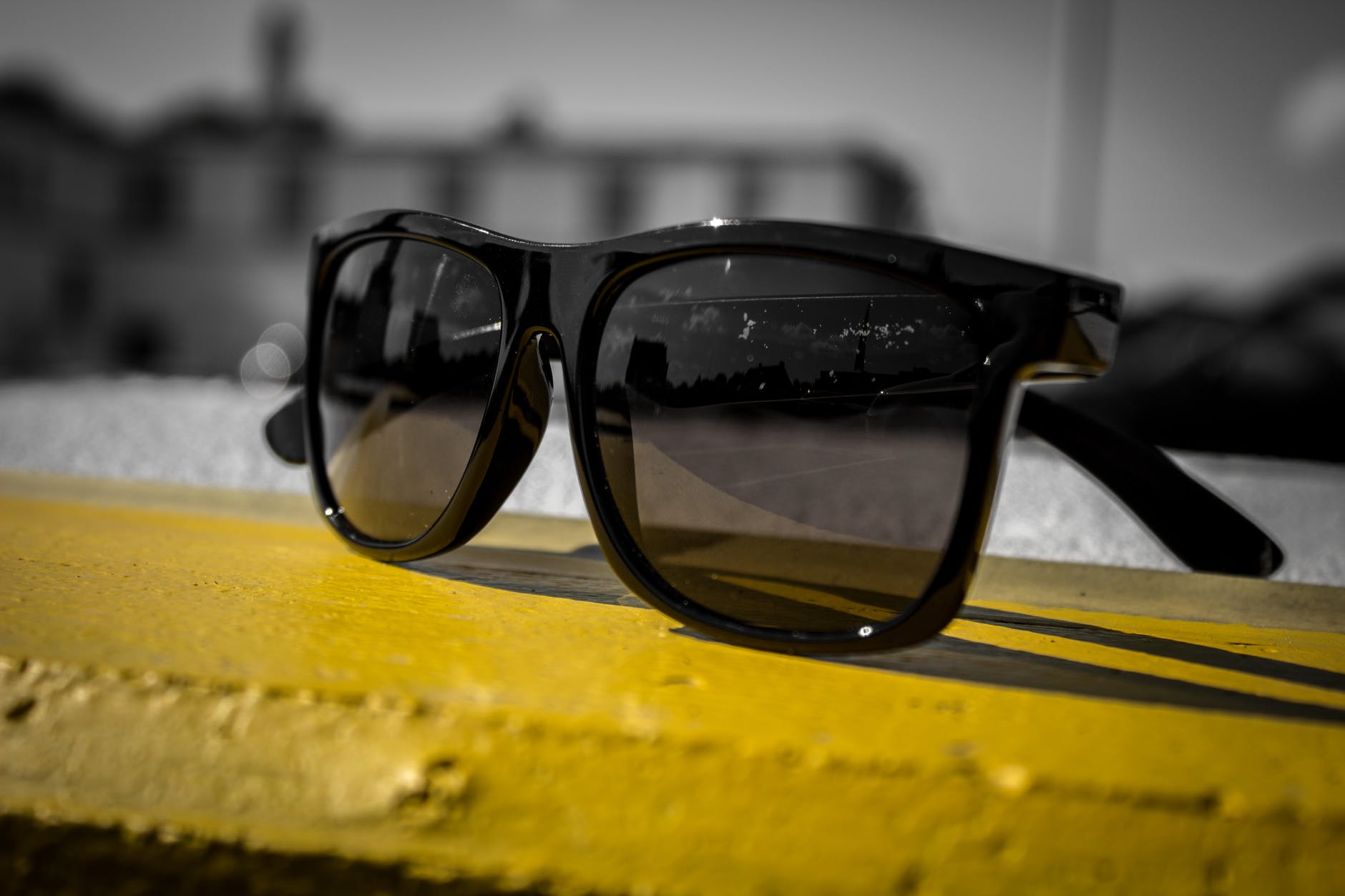 black sunglasses on yellow wooden surface