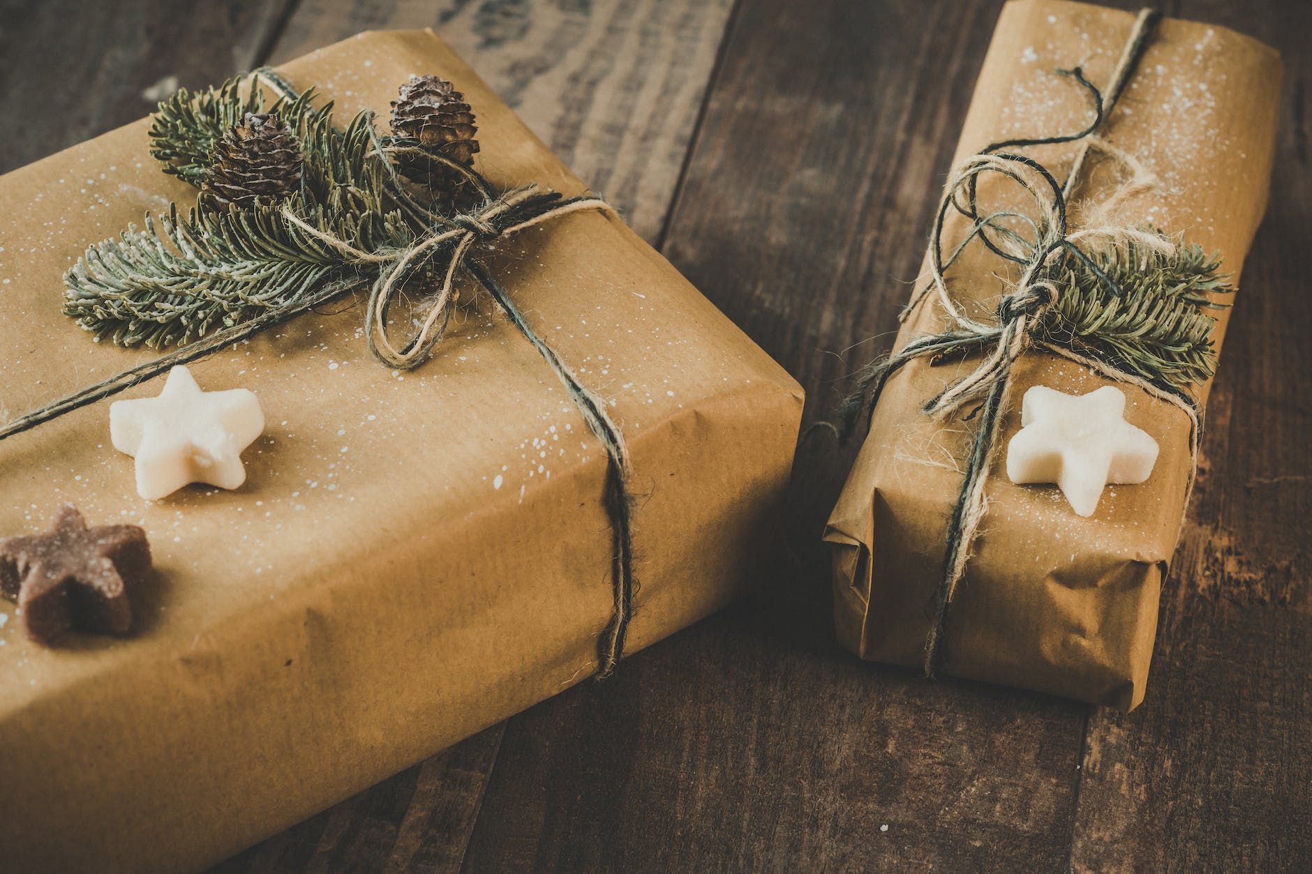 photo of two brown wrapped gifts on wooden table