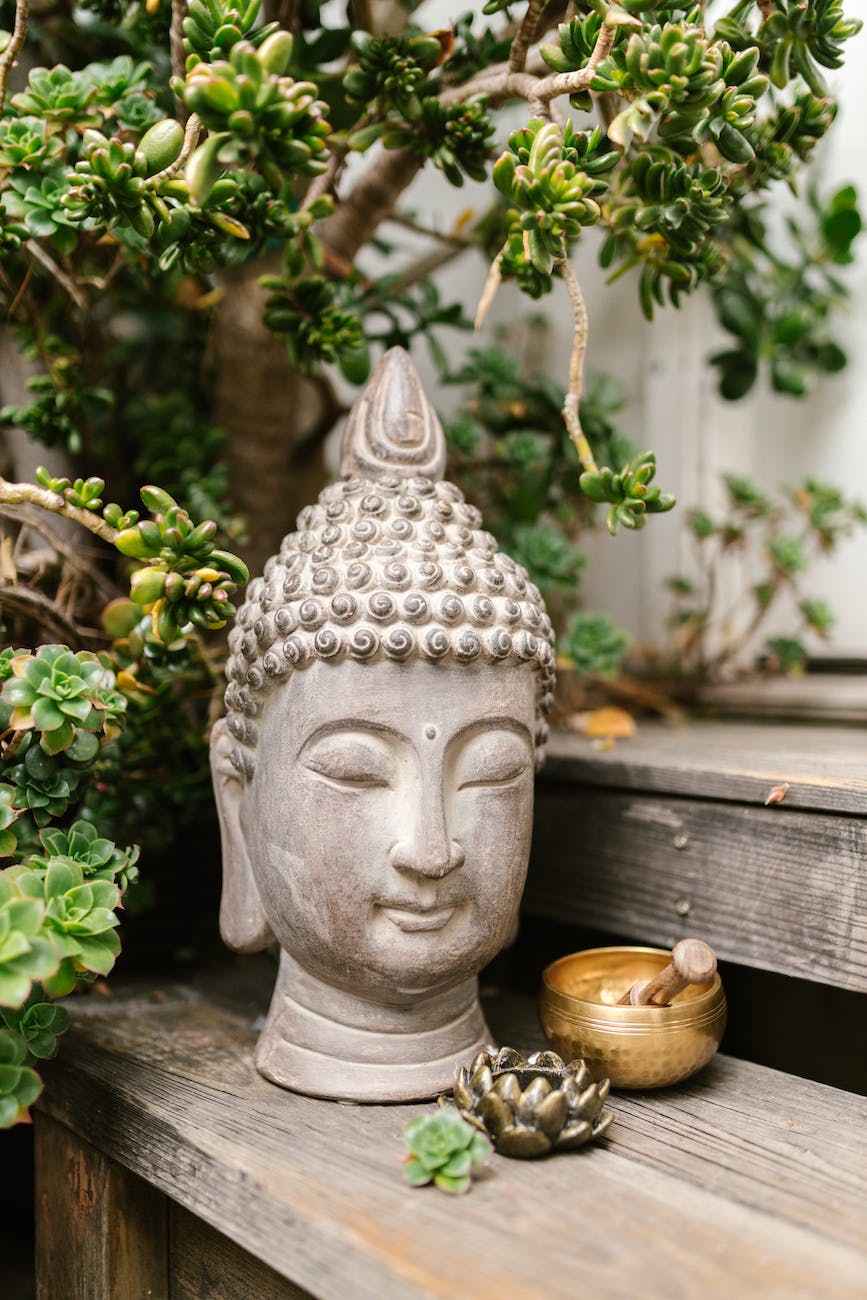 buddha bust over a wooden shaelf