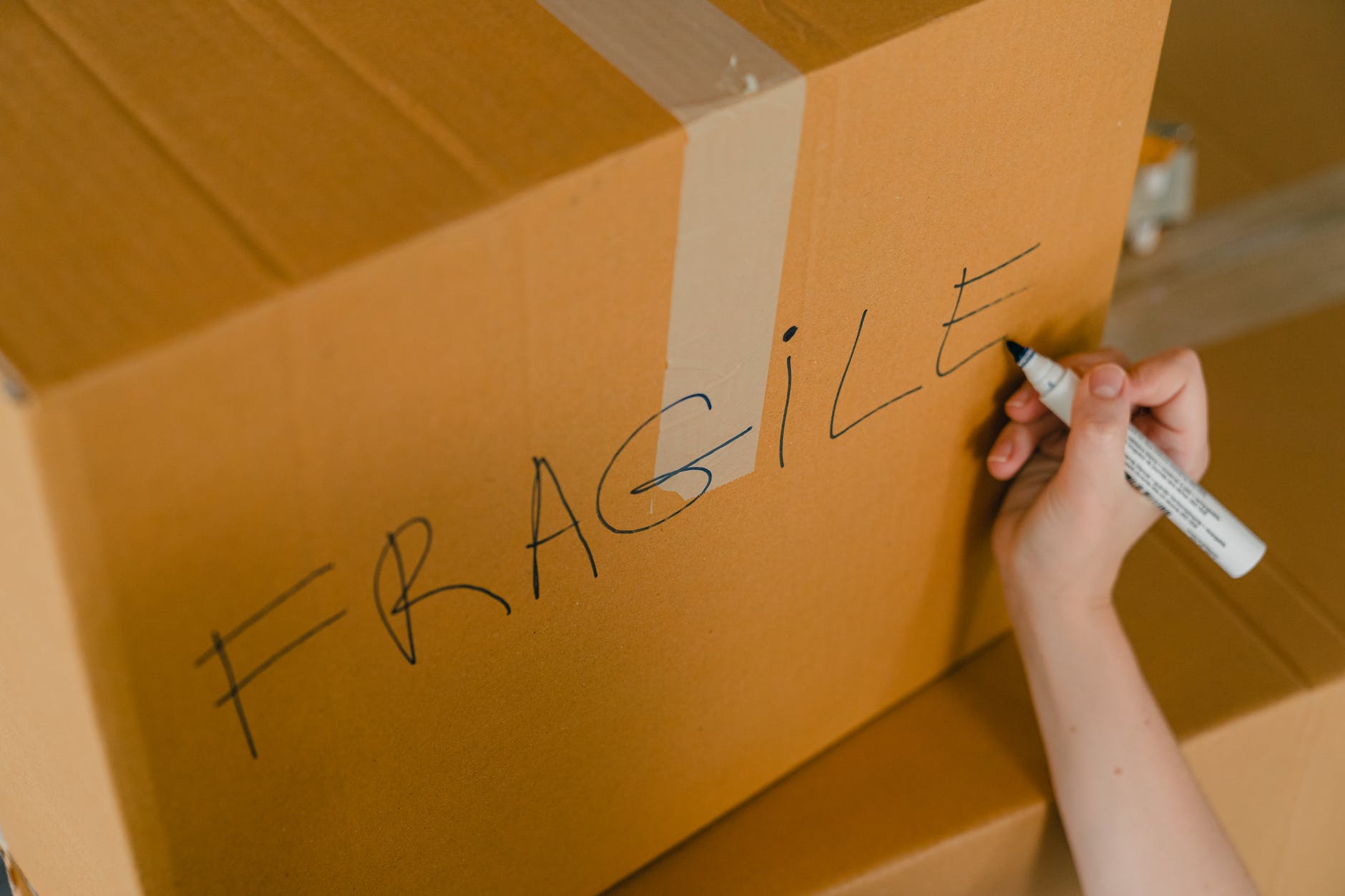 crop person packing box with fragile items